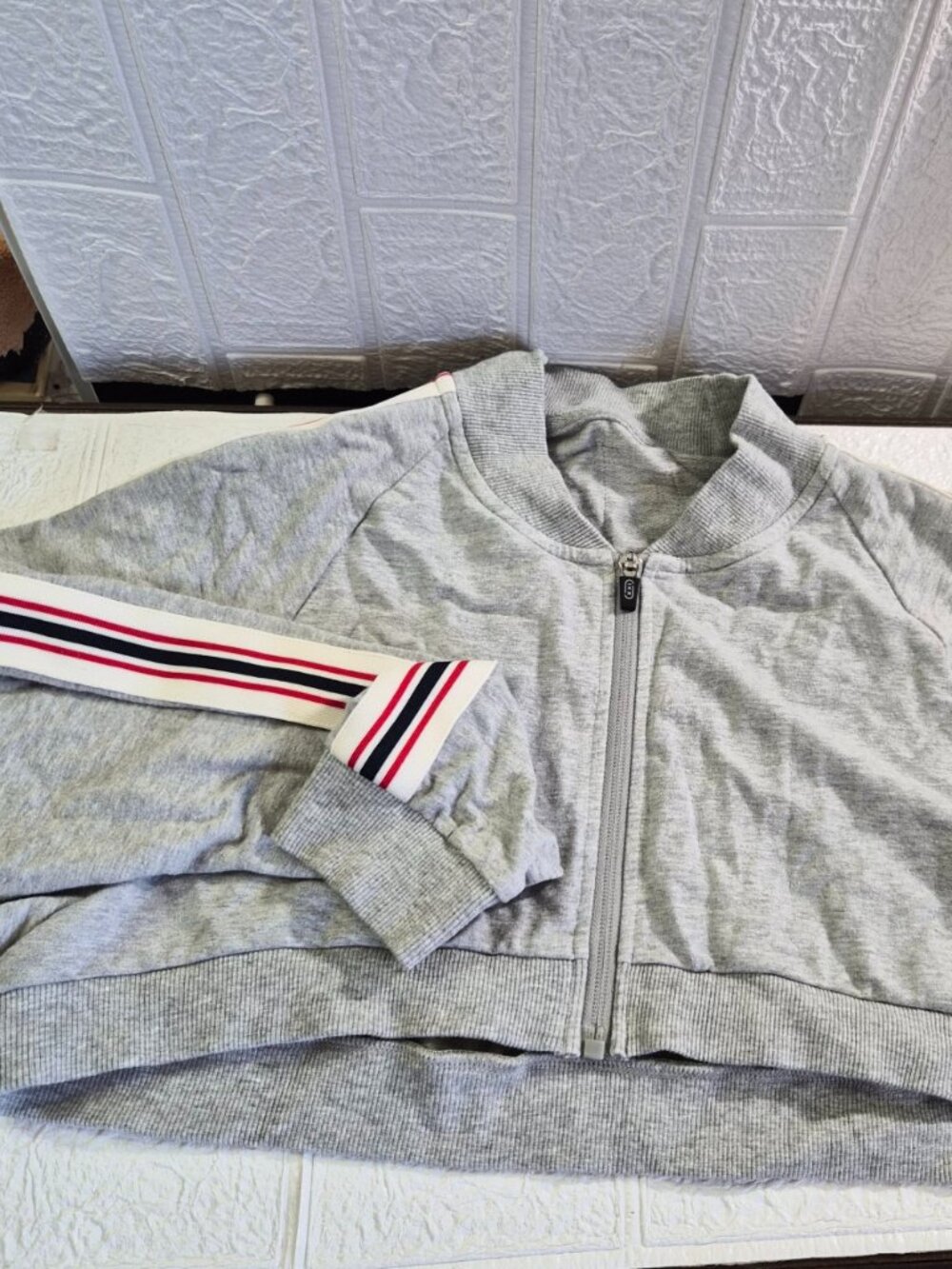 gray cropped zip-up sweatshirt with striped ribbed cuffs and a stand collar